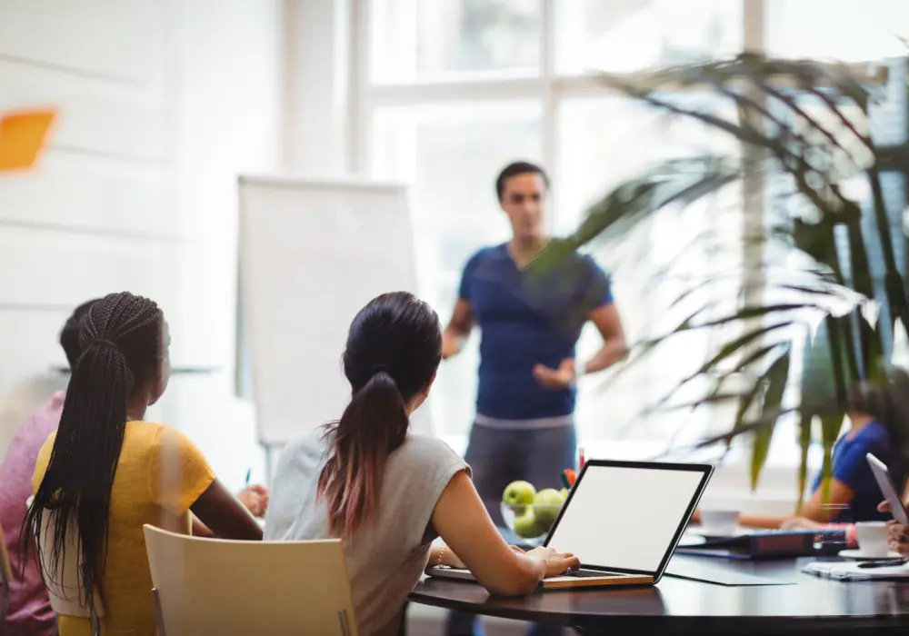 Business executives using laptop during meeting in office