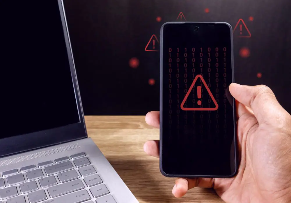 Man holding a smartphone with red triangle caution warning sign for notification error, restricted content or maintenance concept